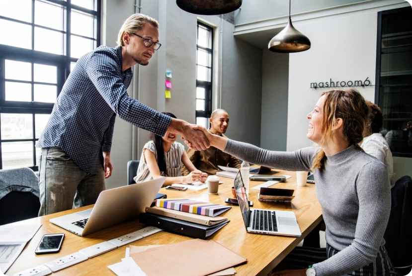 Team handshake in a meeting, showing a creative brand partnership with Shopify Plus Partners India.